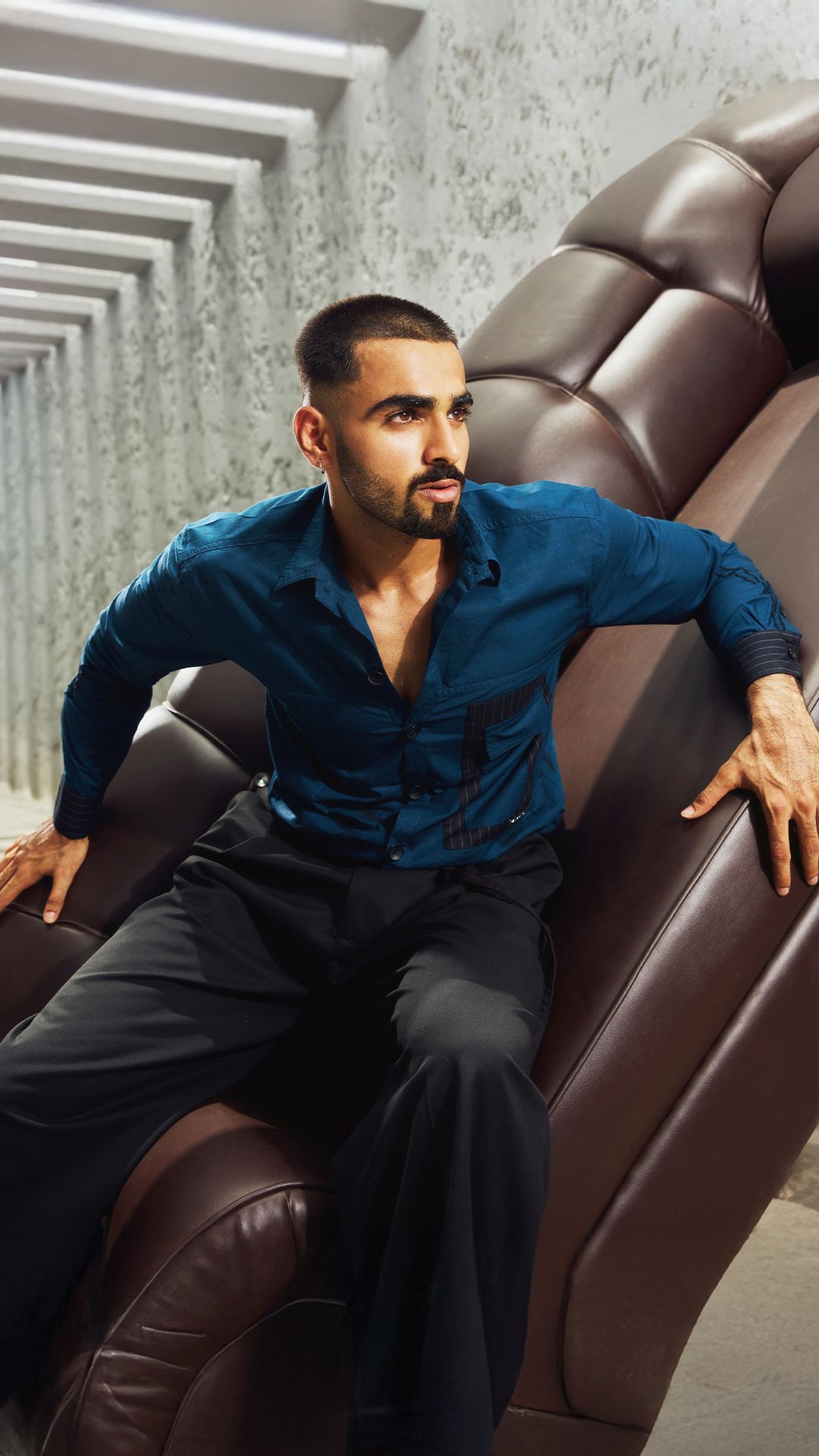 KRWA campaign: model in a teal shirt on a brown leather sofa