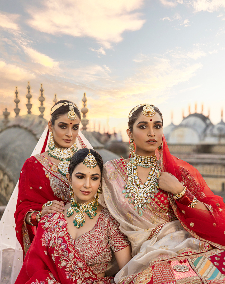 Aari Tari bridal shoot: three brides against palace domes at sunset