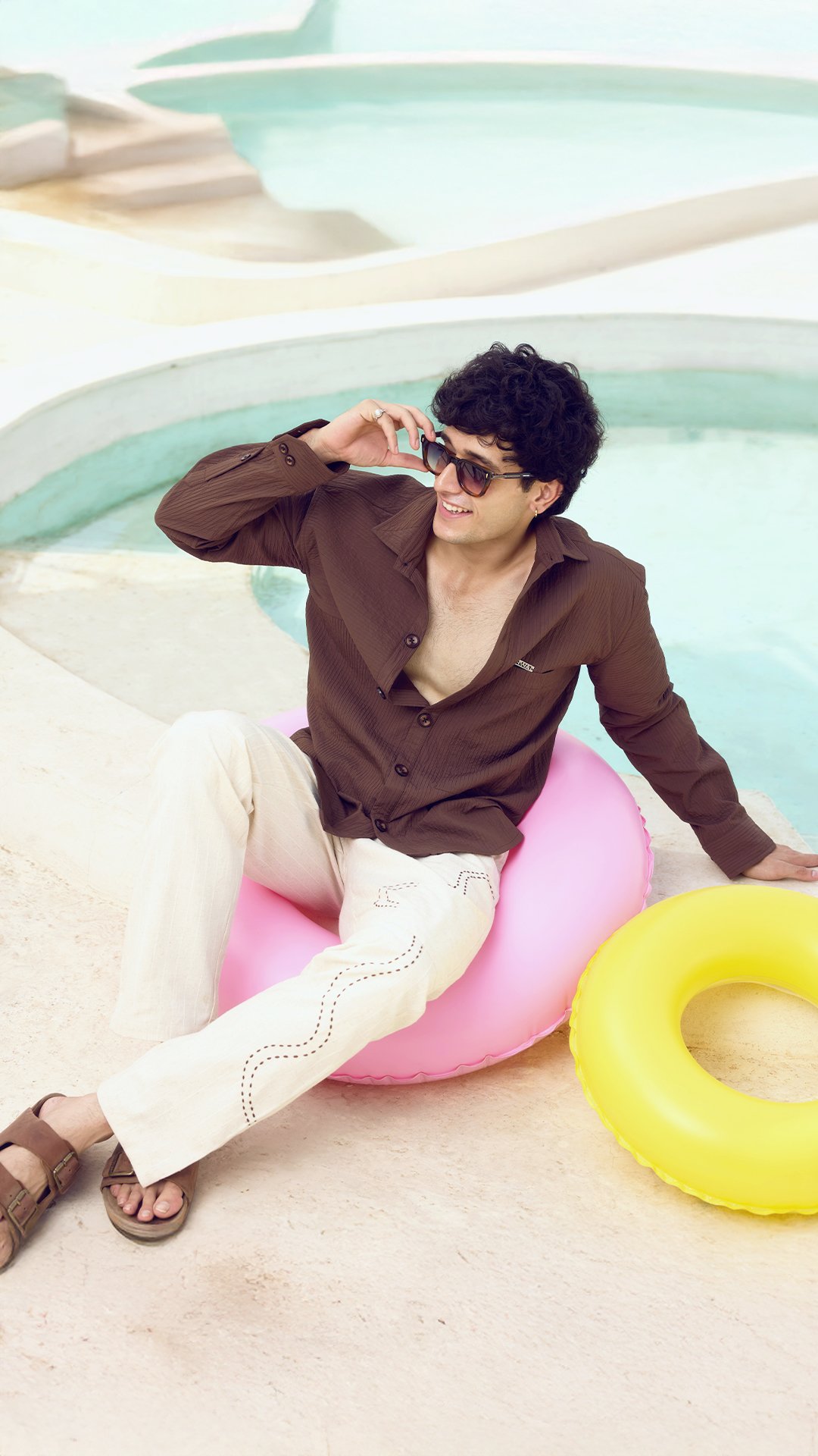KRWA poolside shoot: model in a brown shirt and cream trousers